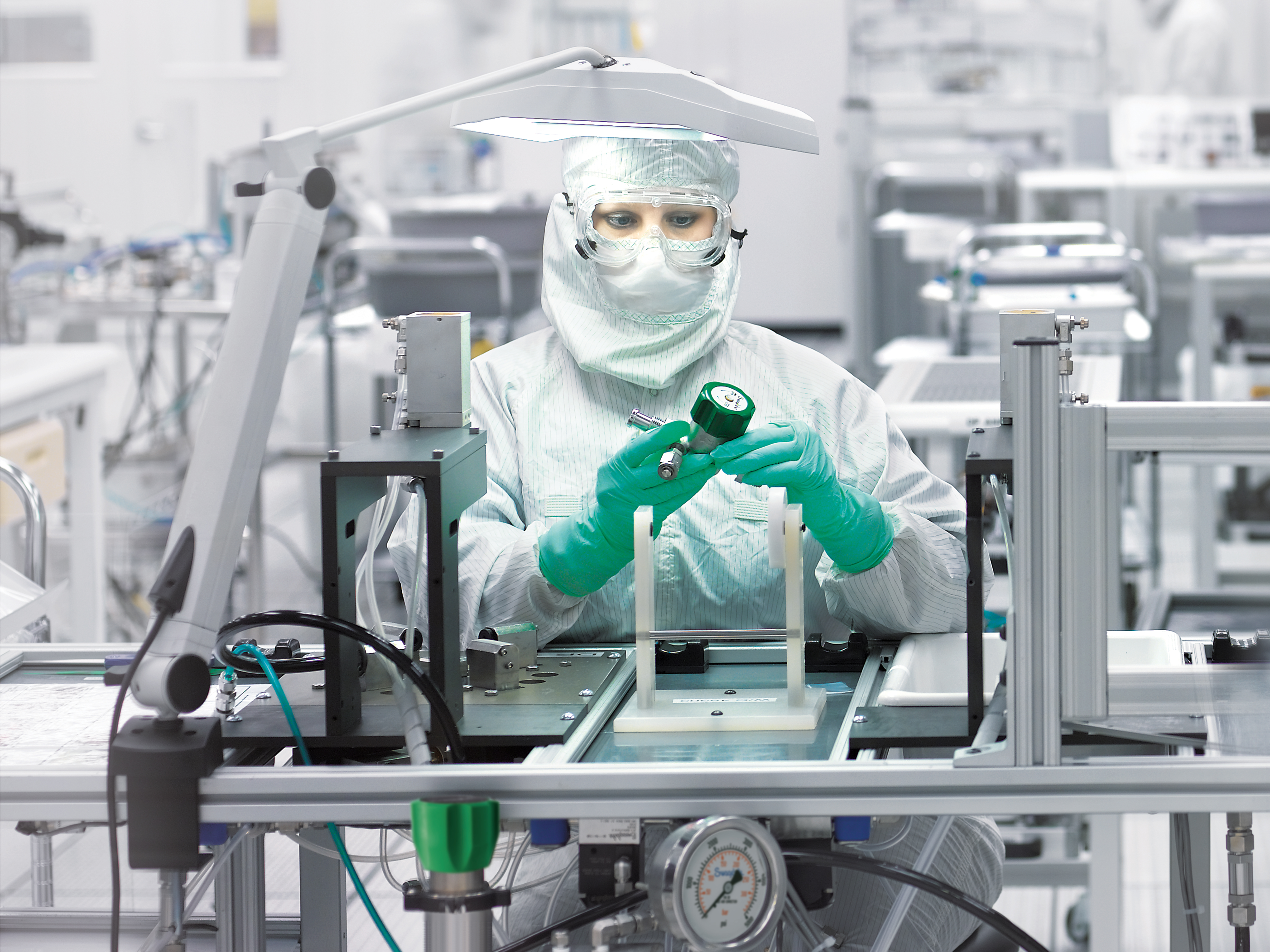 Associate in bunny suit inspecting regulator