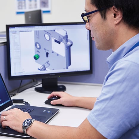 Associate looking at CAD design of a custom solution on computer